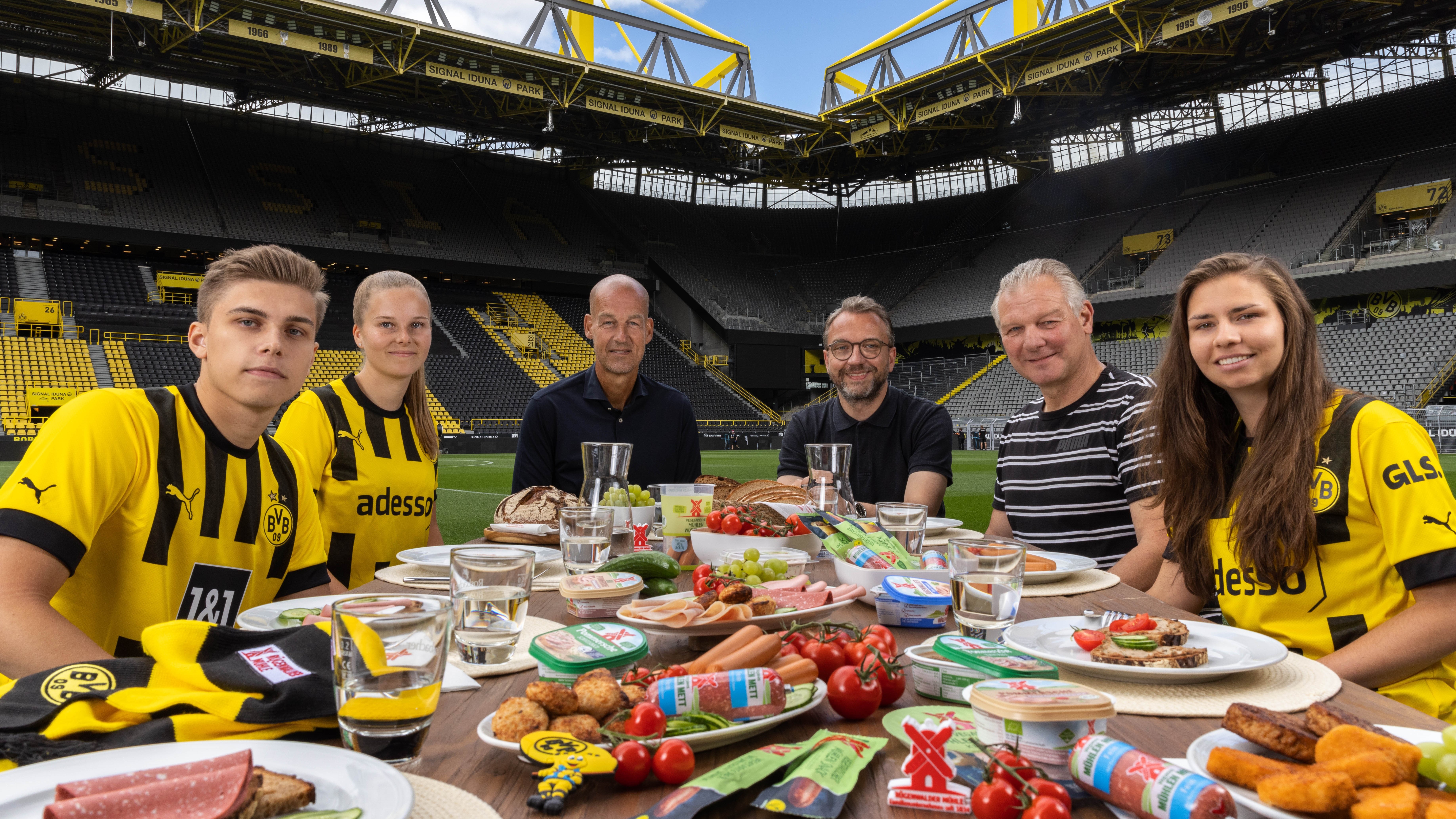 Rügenwalder und Melitta versorgen Borussia Dortmund mit Kaffee, Wurst und mehr - v.l.: Finn Wagner (BVB-Fan), Mandy Reinhardt (BVB-Frauen), Carsten Cramer (Geschäftsführer Borussia Dortmund), Steffen Zeller (CMO Rügenwalder Mühle), Teddy de Beer (BVB-Legende) und Mia Bedarf (BVB-Frauen) - Quelle: Rügenwalder Mühle